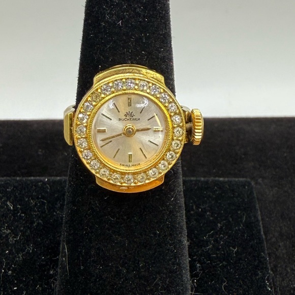 Bucherer finger watch round face encircled by crystals and a gold-tone band - Picture 1 of 7